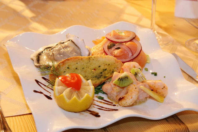Vorspeisenteller mit Fisch, Garnelen und Brot