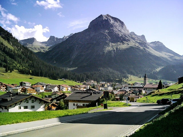 Omeshorn über Lech am Arlberg mit Häusern und grünen Wiesen im Vordergrund