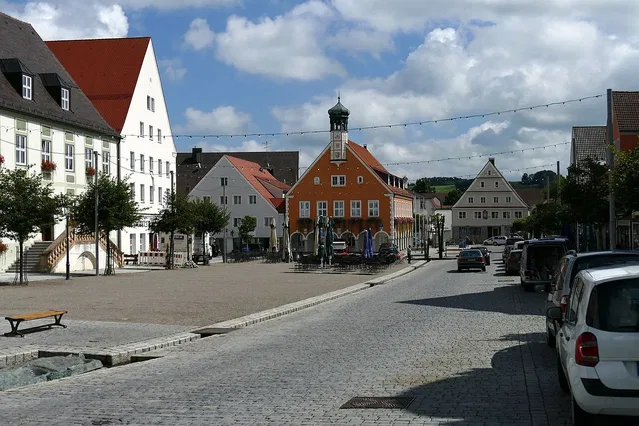 Marktplatz Ottobeuren: orangefarbener Gebäudekomplex mit Turm und umliegende weiße Fachwerkhäuser