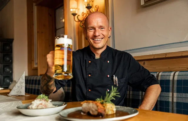Koch mit Bier und Speisen im Gasthof Krone