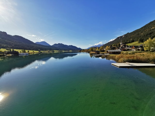 Seeblick bei Techendorf mit Bootshäusern, Kirche und Berglandschaft