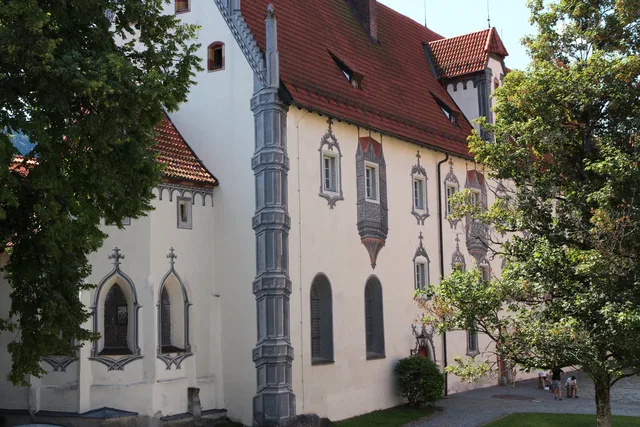 Fassade des Hohen Schlosses mit gemalten Erkern und roten Dächern