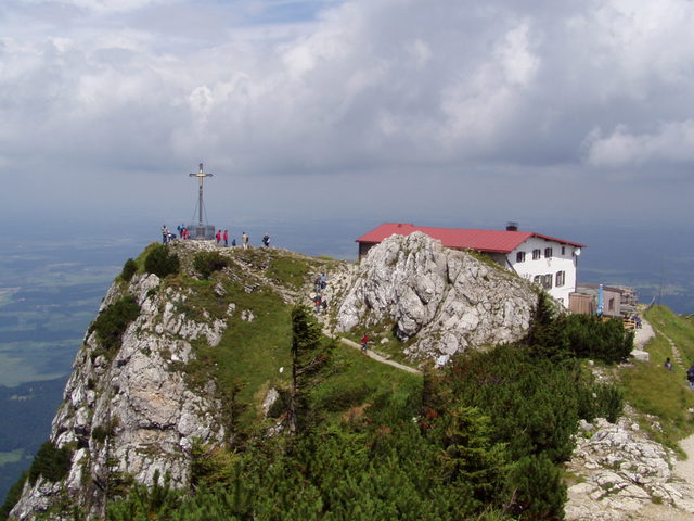 Gipfelkreuz und Hochfellnhaus auf dem felsigen Gipfel des Hochfelln