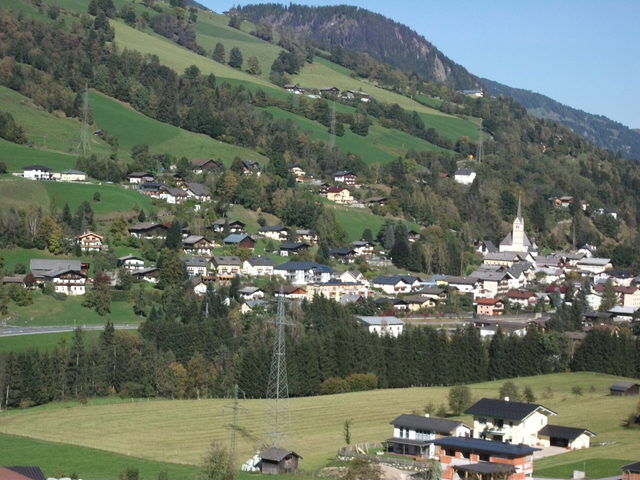 Taxenbach mit Kirche und Häusern an einem grünen Hang