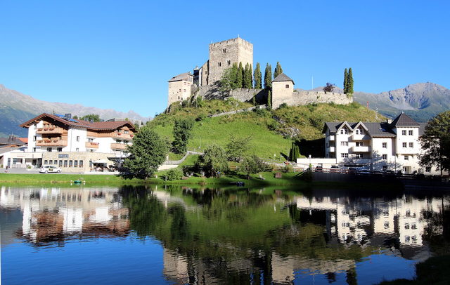 Burg Laudegg in Ladis über dem Dorfweiher mit Spiegelung im Wasser