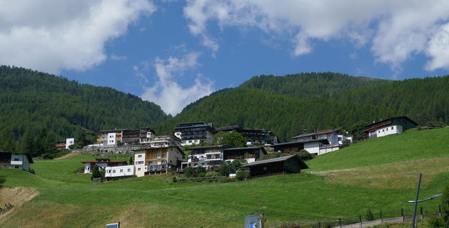 Häuser an den Hängen von Sölden zwischen Wiesen und Bergwald