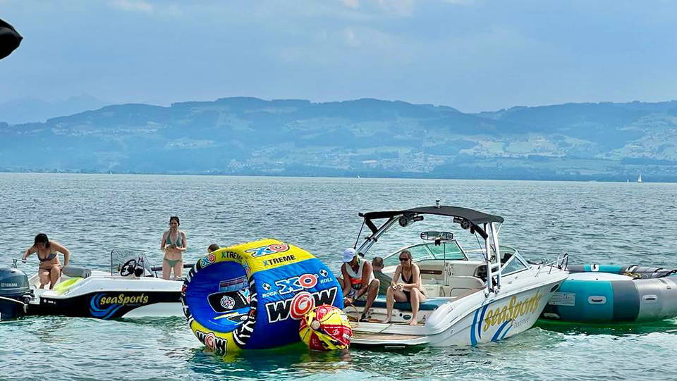 Motorboot und Tubes am Seeufer vor dem Bodenseepanorama