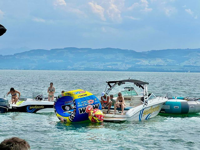 Motorboot und Tubes am Seeufer vor dem Bodenseepanorama