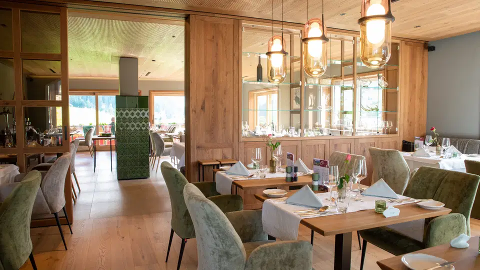 Gedeckte Tische und Pendelleuchten im Restaurantbereich