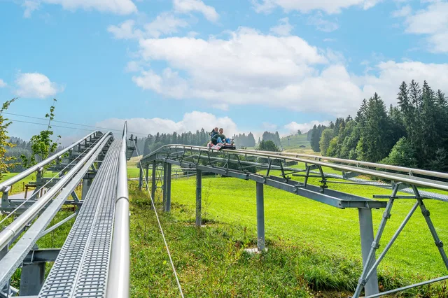 AlpspitzCOASTER auf der Schienenstrecke über grünen Wiesen