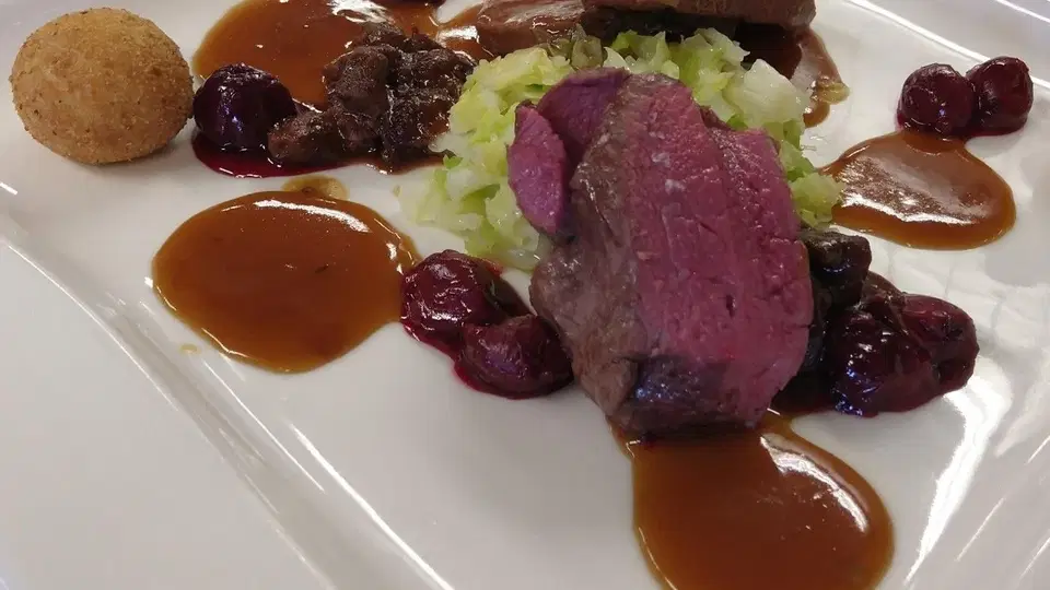 Fleischgericht mit Gemüse und Sauce auf einem Teller