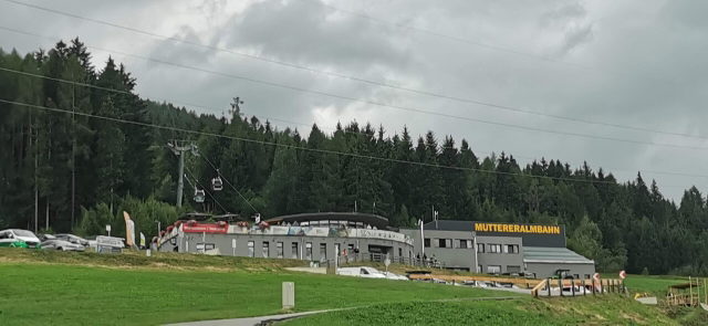 Talstation der Muttereralmbahn mit grünen Wiesen und Gondeln