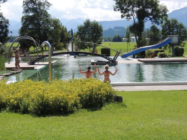 Naturbecken des Vitalparks mit Bergblick, Brücke und Rutsche