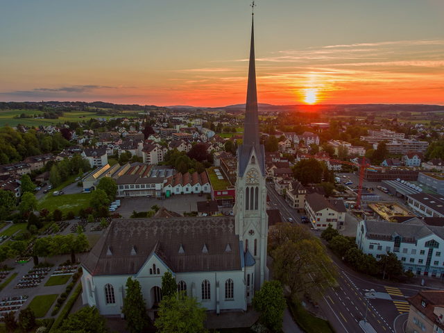 Blick über Amriswil und die Kirche bei Sonnenuntergang