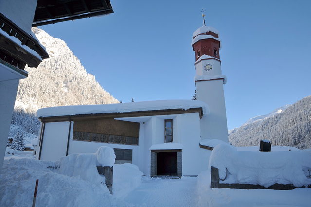 Pfarrkirche von Klösterle am Arlberg vor verschneiten Bergen