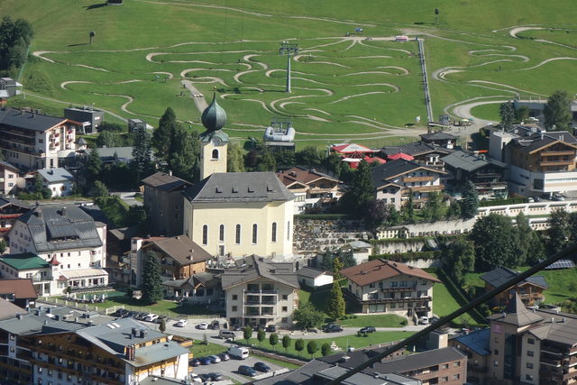 Saalbach mit Kirche und grünen Berghängen