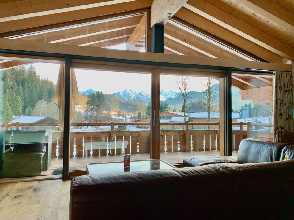 Wohnbereich und Südbalkon der Ferienwohnung Solara mit Blick auf die Berge