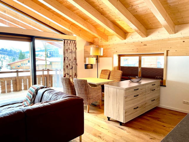 Heller Wohnbereich der Ferienwohnung Solara mit Sofa, Esstisch und Wand-Stockbett