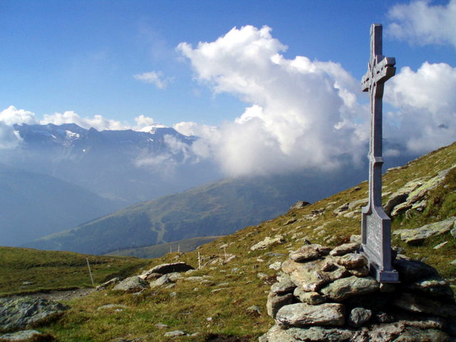 Gipfelkreuz auf dem Geiseljoch vor der Berglandschaft