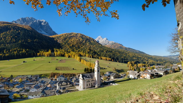 Sexten im Herbst mit der Pfarrkirche Petrus und Paulus und den umliegenden Bergen