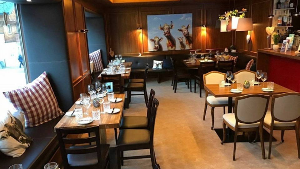 Gastraum der Uusziit mit Holztischen und Weinbar