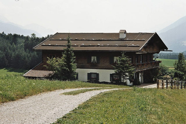 Bergdoktorhaus in Wildermieming vor Wiesen und Berglandschaft
