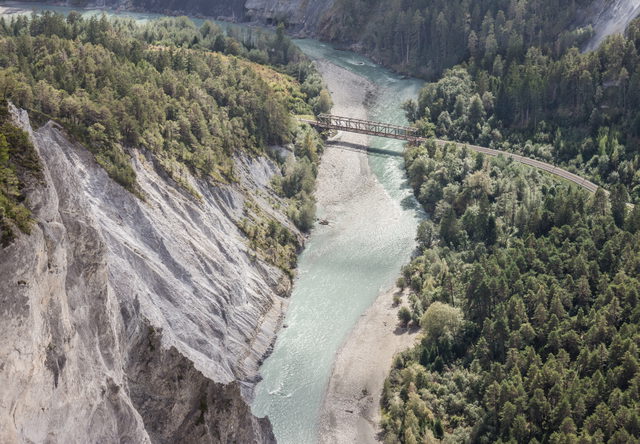 Blick von Il Spir in die Rheinschlucht mit Vorderrhein und Eisenbahnbrücke