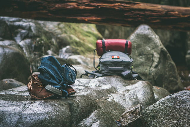 Symbolbild: Wanderschuhe und Rucksack auf einem Felsen