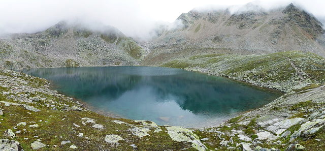 Gaislacher See bei Sölden zwischen felsigen Berghängen und tiefen Wolken