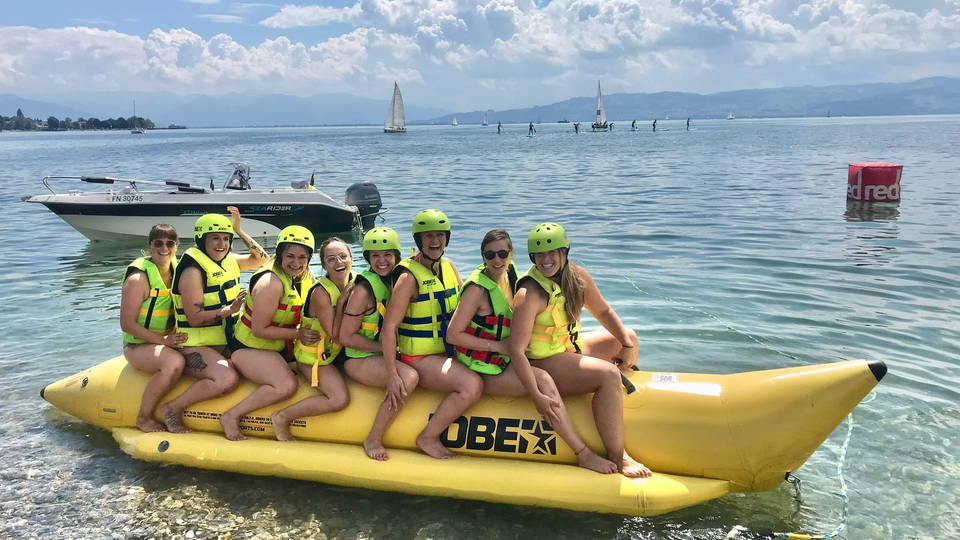 Gruppe mit Schwimmwesten auf einem gelben Banana-Ride am Seeufer