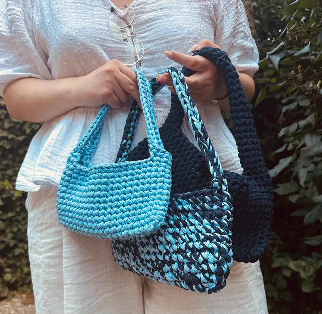 Drei gehäkelte Taschen in Blau und Türkis.