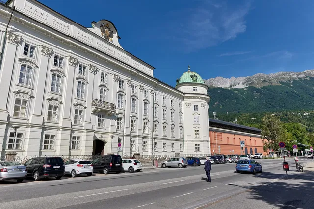 Historisches weißes Gebäude vor einer Bergkulisse