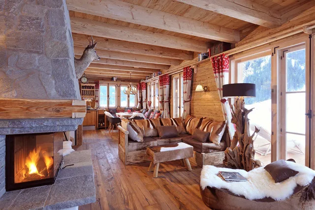 Wohnbereich mit Kamin, Ledersofa und großen Fenstern