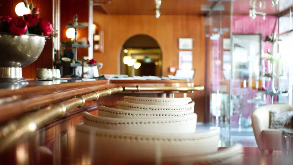 Hotelbar mit Holztheke und gepolsterten Barhockern
