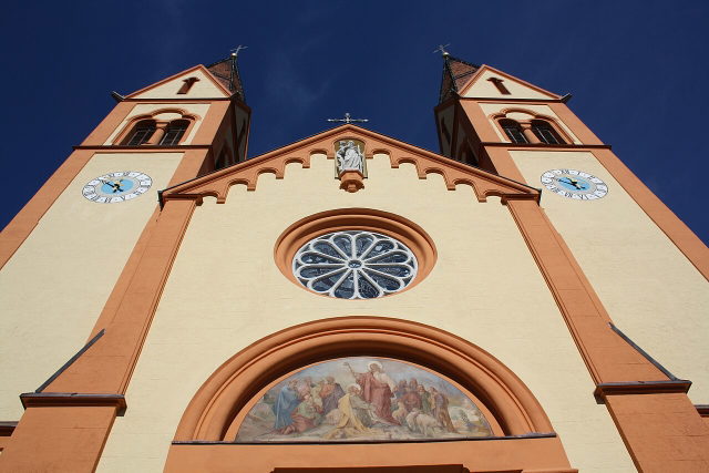 Blick entlang der Fassade und Türme der Pfarrkirche St. Peter und Paul in Telfs