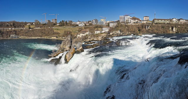 Rheinfall mit Felsen im Wasser und Neuhausen am gegenüberliegenden Ufer