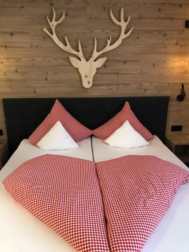 Doppelbett mit rot-weiß karierter Bettwäsche
