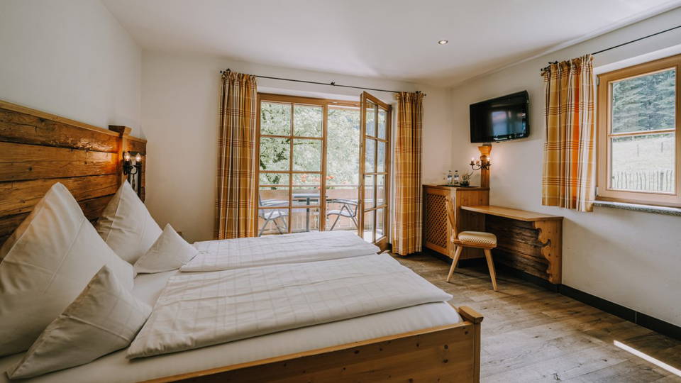 Doppelbett und Fensterfront im Zimmer Silberdistel.