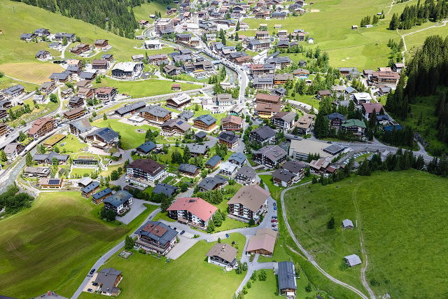 Luftaufnahme von Lech am Arlberg und den umliegenden grünen Berghängen