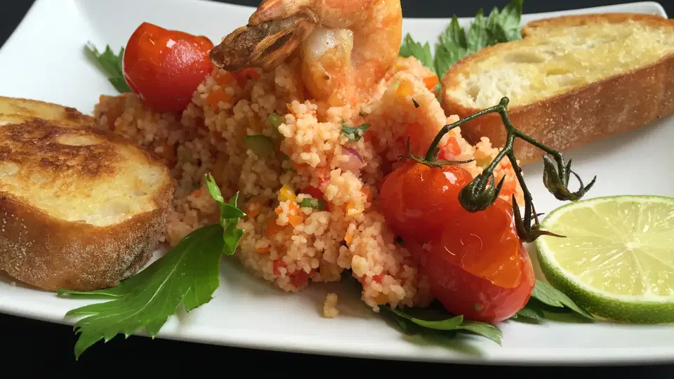 Garnelen auf Couscous mit Tomaten, Brot und Limette