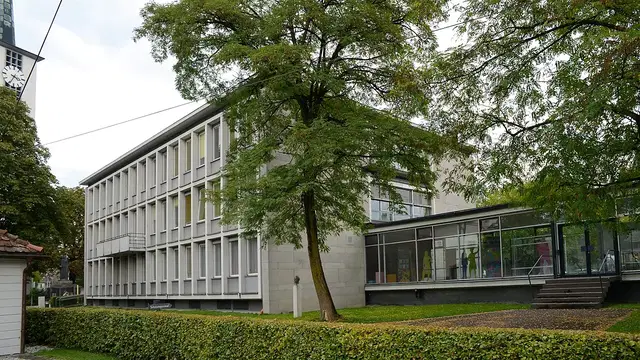 Rathaus von Lustenau mit Bäumen im Vordergrund. Ortsmotiv zur Ausflugsplanung.