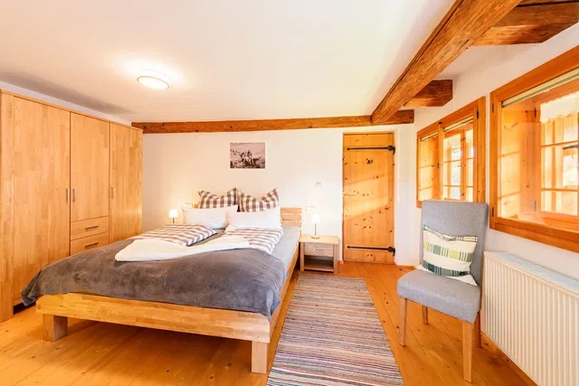 Schlafzimmer mit Doppelbett und Holzbalken