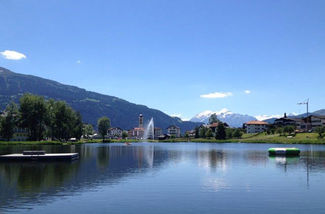 Laaxersee mit umliegenden Häusern und Bergen am Lag Grond