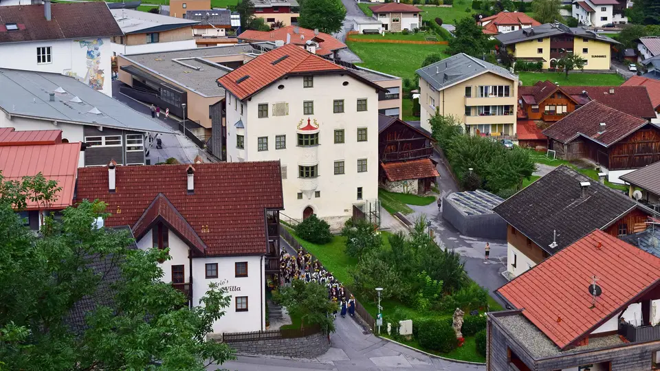 Blick auf den historischen Turm des Turmmuseums zwischen den Häusern von Oetz