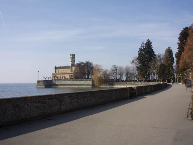 Promenade am Bodensee in Langenargen mit Burg am Ufer und Bäumen