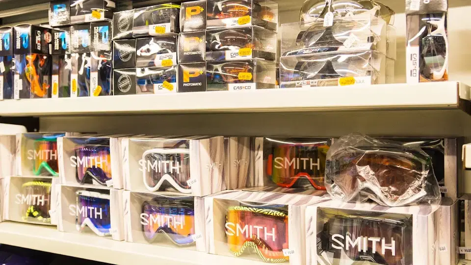 Skibrillen in Kartons im Regal, Smith-Marken deutlich sichtbar.