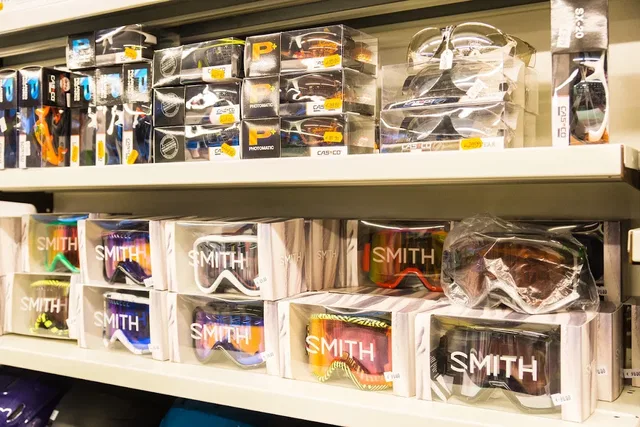 Skibrillen in Kartons im Regal, Smith-Marken deutlich sichtbar.