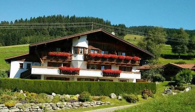 Haus am Anger in Jungholz mit blumengeschmückten Balkonen