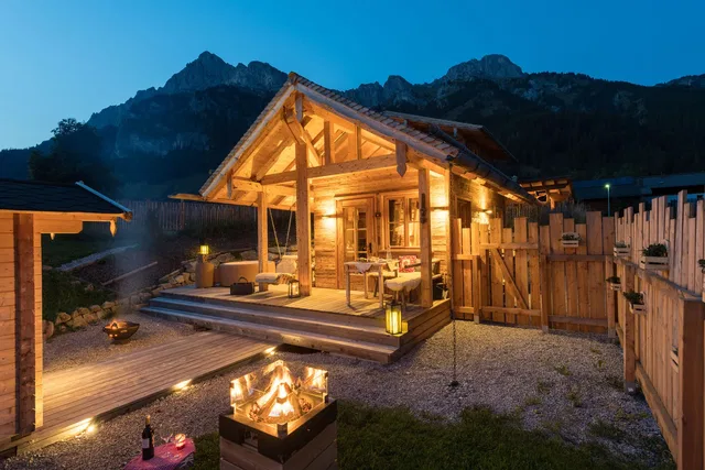 Beleuchtetes Chalet mit Garten und Feuerstelle am Abend