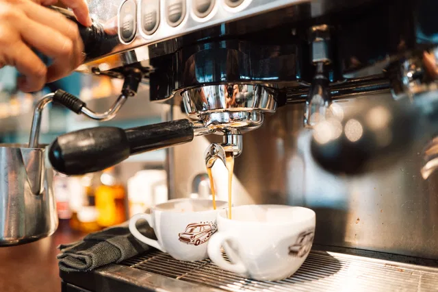 Espressomaschine gießt Kaffee in zwei Tassen
